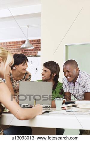 Four people having meeting around laptop. View Large Photo Image Stock Image - Four people having meeting around laptop.. Fotosearch