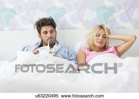 Frustrated sick couple lying in bed at home View Large Photo Image Stock Photography - Frustrated sick couple lying in bed at home. Fotosearch