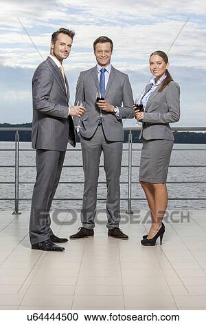 Full length portrait of young businesspeople holding wineglasses on terrace View Large Photo Image Stock Image - Full length portrait of young businesspeople holding wineglasses on terrace. Fotosearch