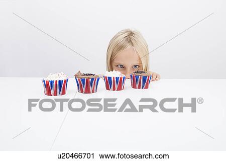 Girl staring at cupcakes on table View Large Photo Image Stock Image - Girl staring at cupcakes on table. Fotosearch