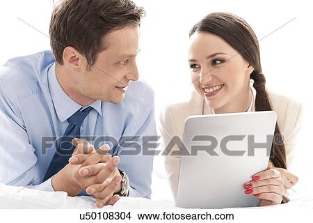 Happy business couple with digital tablet looking at each other in hotel View Large Photo Image Picture - Happy business couple with digital tablet looking at each other in hotel. Fotosearch