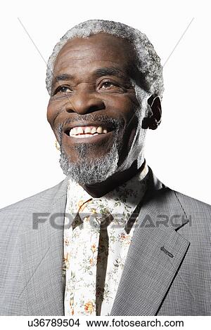 Happy senior man smiling while looking away against white background View Large Photo Image Picture - Happy senior man smiling while looking away against white background. Fotosearch