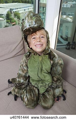 High angle portrait of happy boy in dinosaur costume sitting on sofa at home View Large Photo Image Picture - High angle portrait of happy boy in dinosaur costume sitting on sofa at home. Fotosearch
