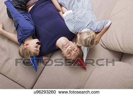 High angle view of father and children with artificial mustache and party hat sleeping on sofa bed View Large Photo Image Stock Image - High angle view of father and children with artificial mustache and party hat sleeping on sofa bed. Fotosearch