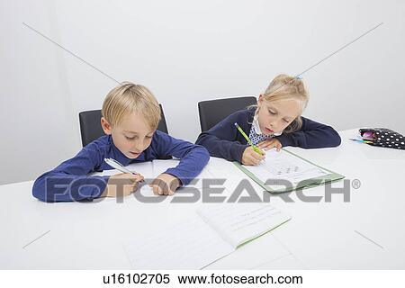 Little boy and daughter writing on documents at table View Large Photo Image Stock Photography - Little boy and daughter writing on documents at table. Fotosearch