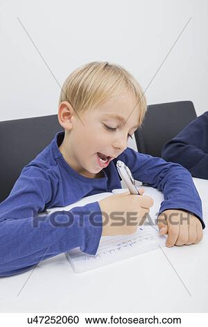 Little boy writing in book at table View Large Photo Image Stock Image - Little boy writing in book at table. Fotosearch