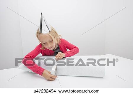 Little girl wrapping birthday gift at table in house View Large Photo Image Picture - Little girl wrapping birthday gift at table in house. Fotosearch