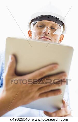 Low angle view of male architect using tablet PC against sky View Large Photo Image Stock Image - Low angle view of male architect using tablet PC against sky. Fotosearch