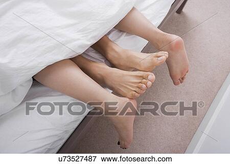 Low section of intimate couple in bed View Large Photo Image Stock Photo - Low section of intimate couple in bed. Fotosearch