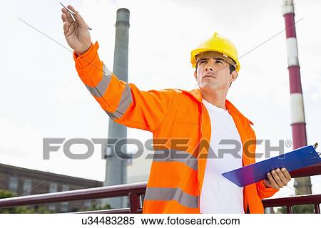 Male architect with clipboard at industry View Large Photo Image Stock Photography - Male architect with clipboard at industry. Fotosearch