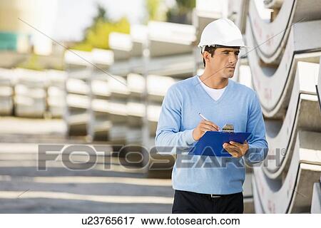 Male supervisor with clipboard inspecting stock at site View Large Photo Image Stock Photo - Male supervisor with clipboard inspecting stock at site. Fotosearch