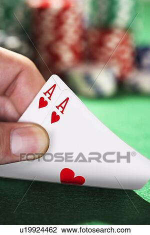 Stock Image - Man peeked at two cards close up of hand. Fotosearch