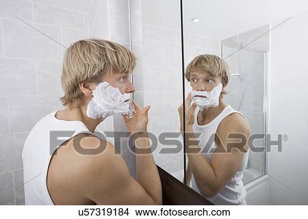Picture - Mid-adult man applying shaving cream in bathroom. Fotosearch