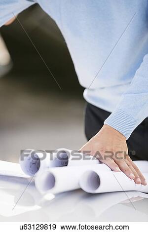 Midsection of architect with blueprints View Large Photo Image Stock Photo - Midsection of architect with blueprints. Fotosearch