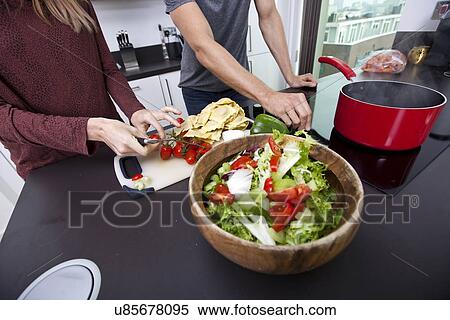 Midsection of couple cooking together at kitchen counter View Large Photo Image Stock Photography - Midsection of couple cooking together at kitchen counter. Fotosearch