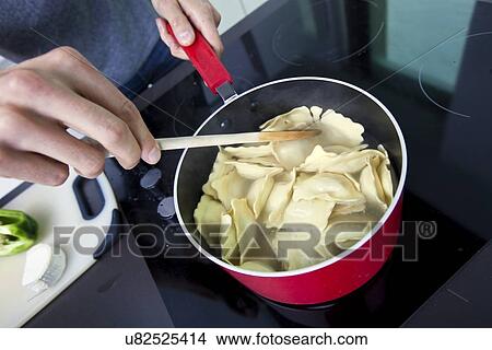 Midsection of man cooking pasta on stove in kitchen View Large Photo Image Picture - Midsection of man cooking pasta on stove in kitchen. Fotosearch