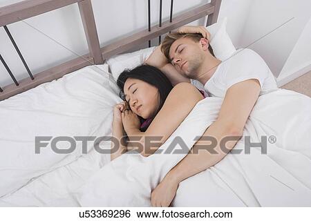 Multiethnic couple resting in bed View Large Photo Image Stock Photograph - Multiethnic couple resting in bed. Fotosearch