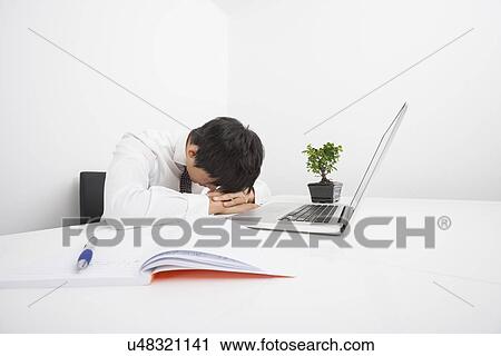 Over-worked mid adult businessman sleeping by laptop at desk View Large Photo Image Stock Image - Over-worked mid adult businessman sleeping by laptop at desk. Fotosearch
