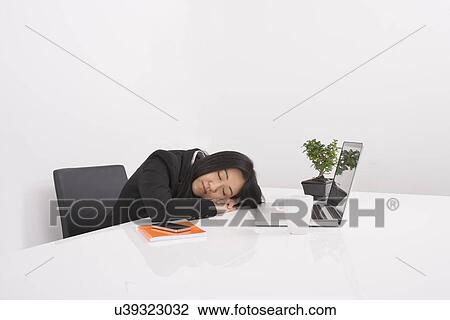 Overworked businesswoman resting at desk in office View Large Photo Image Stock Image - Overworked businesswoman resting at desk in office. Fotosearch