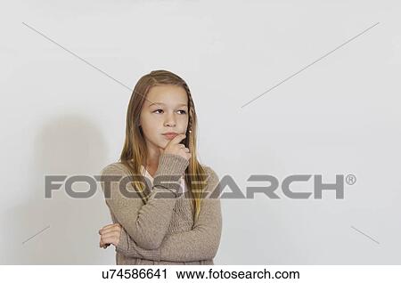 Stock Image - Pensive Schoolgirl against whiteboard. Fotosearch