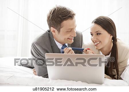Playful business couple with laptop in hotel room View Large Photo Image Stock Image - Playful business couple with laptop in hotel room. Fotosearch