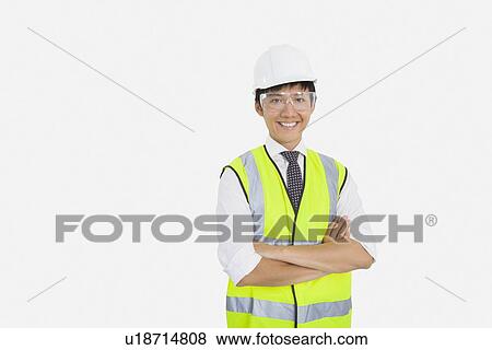 Stock Photo - Portrait of Asian construction worker with arms crossed over white background. Fotosearch