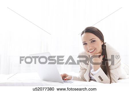 Portrait of beautiful businesswoman using laptop in hotel View Large Photo Image Stock Image - Portrait of beautiful businesswoman using laptop in hotel. Fotosearch