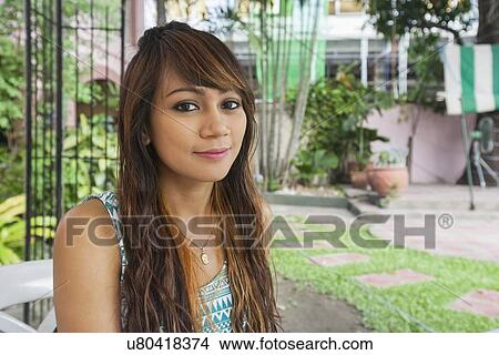 Portrait of beautiful young woman smiling outdoors, Manila, Philippines View Large Photo Image Picture - Portrait of beautiful young woman smiling outdoors, Manila, Philippines. Fotosearch