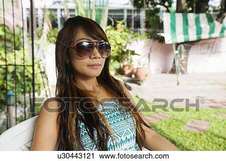 Stock Image - Portrait of beautiful young woman smiling outdoors, Manila, Philippines. Fotosearch