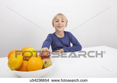 Picture - Portrait of boy with fruit bowl at table. Fotosearch