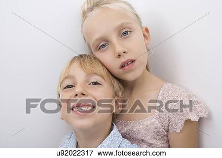 Stock Photo - Portrait of brother and sister over gray background. Fotosearch