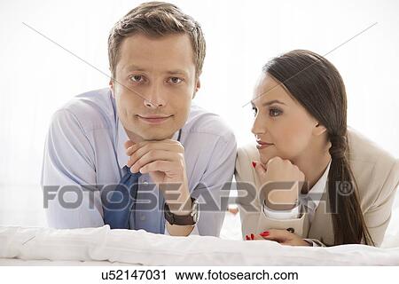 Stock Image - Portrait of businessman with coworker in hotel. Fotosearch