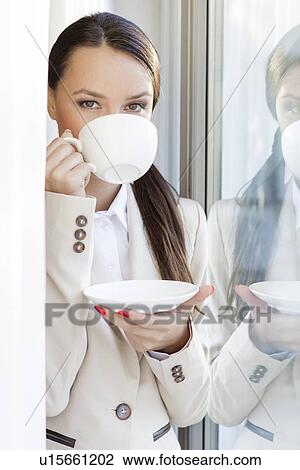Portrait of businesswoman drinking coffee in office View Large Photo Image Stock Image - Portrait of businesswoman drinking coffee in office. Fotosearch