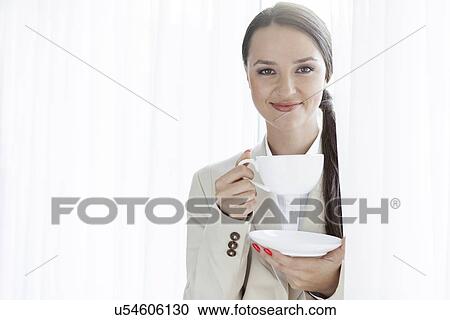 Portrait of businesswoman having coffee in office View Large Photo Image Stock Image - Portrait of businesswoman having coffee in office. Fotosearch