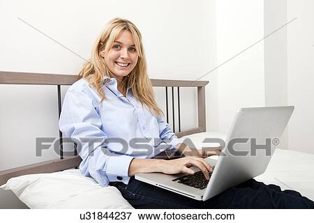 Portrait of businesswoman using laptop in bed View Large Photo Image Stock Photo - Portrait of businesswoman using laptop in bed. Fotosearch