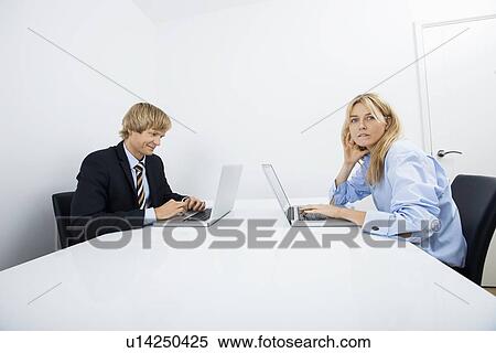 Portrait of businesswoman with coworker working in office View Large Photo Image Stock Photography - Portrait of businesswoman with coworker working in office. Fotosearch