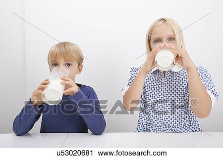 Portrait of children drinking milk at table View Large Photo Image Stock Image - Portrait of children drinking milk at table. Fotosearch