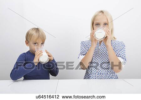 Portrait of children drinking milk at table View Large Photo Image Stock Image - Portrait of children drinking milk at table. Fotosearch