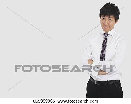 Portrait of confident businessman with arms crossed standing over white background View Large Photo Image Stock Photography - Portrait of confident businessman with arms crossed standing over white background. Fotosearch
