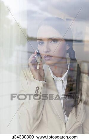 Portrait of confident businesswoman using cell phone in office View Large Photo Image Stock Image - Portrait of confident businesswoman using cell phone in office. Fotosearch