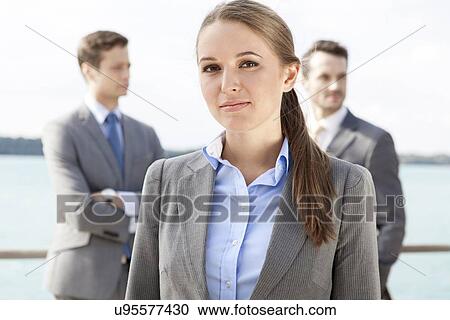 Portrait of confident businesswoman standing with coworkers in background on terrace View Large Photo Image Stock Image - Portrait of confident businesswoman standing with coworkers in background on terrace. Fotosearch