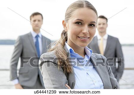 Portrait of confident businesswoman standing with coworkers on terrace View Large Photo Image Stock Photo - Portrait of confident businesswoman standing with coworkers on terrace. Fotosearch