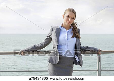 Stock Photography - Portrait of confident businesswoman leaning on terrace railings. Fotosearch