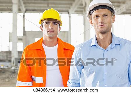 Portrait of confident male architects at construction site View Large Photo Image Picture - Portrait of confident male architects at construction site. Fotosearch