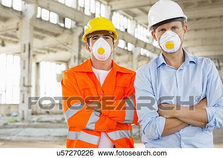 Portrait of confident male construction workers in protective workwear at site View Large Photo Image Stock Photograph - Portrait of confident male construction workers in protective workwear at site. Fotosearch