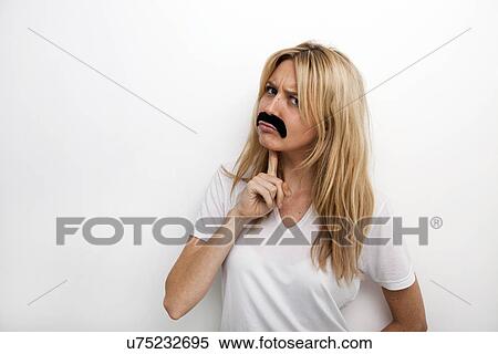 Portrait of confused in fake mustache against white background View Large Photo Image Stock Photography - Portrait of confused in fake mustache against white background. Fotosearch