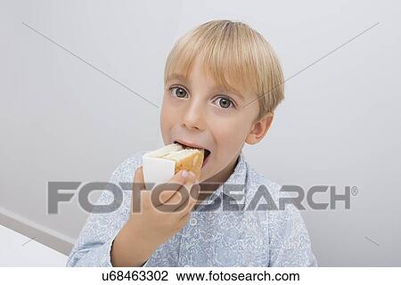 Portrait of cute boy eating cake slice in house View Large Photo Image Stock Image - Portrait of cute boy eating cake slice in house. Fotosearch