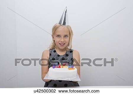 Portrait of cute girl holding birthday cake at home View Large Photo Image Stock Image - Portrait of cute girl holding birthday cake at home. Fotosearch