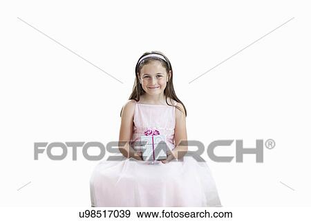 Portrait of cute girl holding gift box over white background View Large Photo Image Stock Photo - Portrait of cute girl holding gift box over white background. Fotosearch