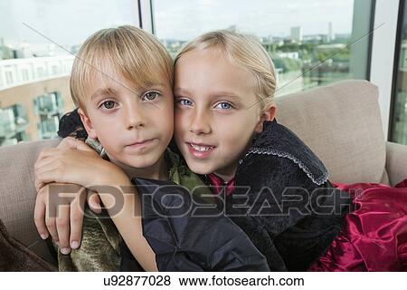 Portrait of cute siblings in dinosaur and vampire costumes at home View Large Photo Image Stock Photo - Portrait of cute siblings in dinosaur and vampire costumes at home. Fotosearch